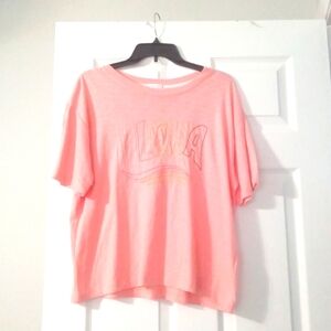 Peach shirt that says ALOHA